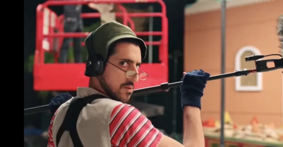 Malek in character as a boom operator on a film set